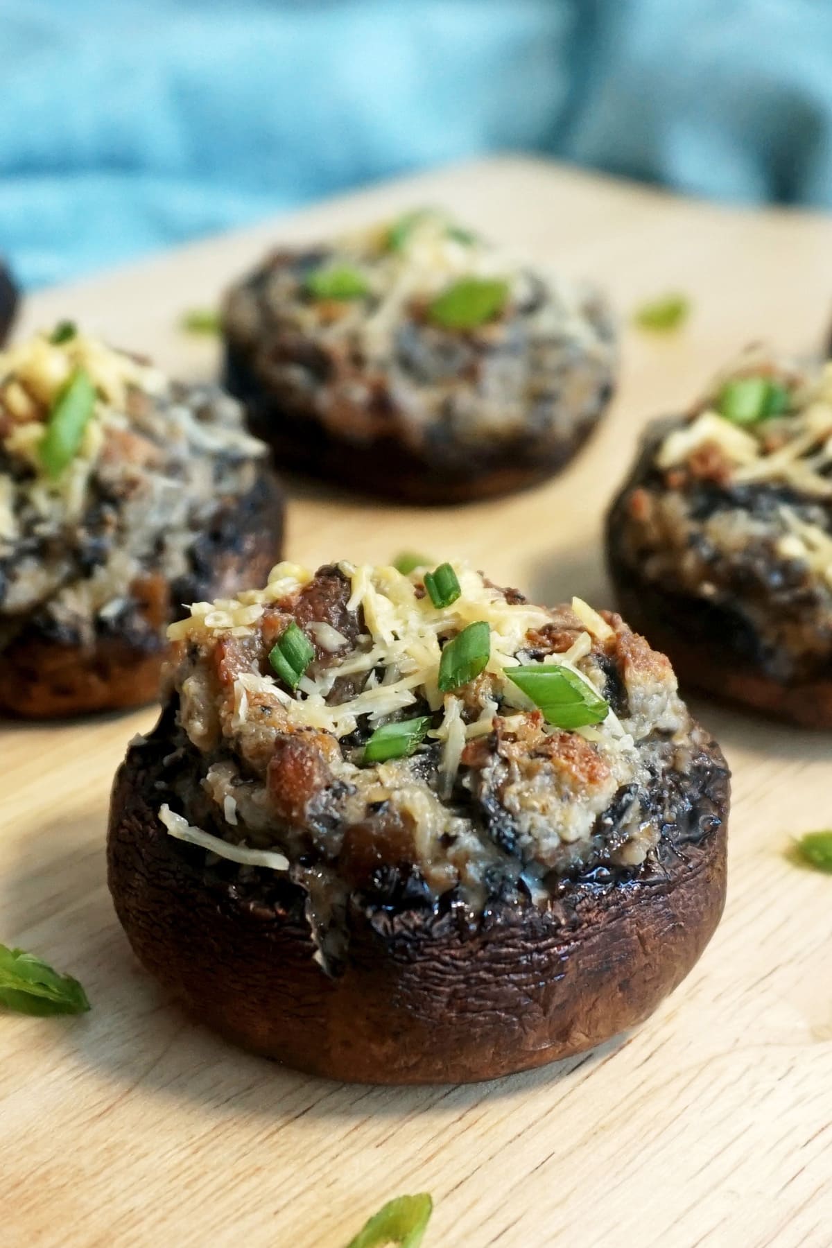 Closeup of a stuffed mushroom with bacon and garnished with green onions