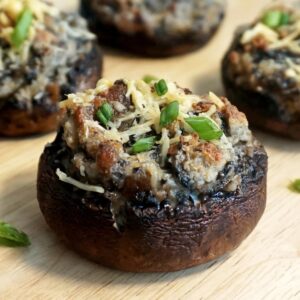 Closeup of a stuffed mushroom with bacon and garnished with green onions