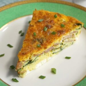 Slice of Ham and Cheddar Crustless Quiche on a plate