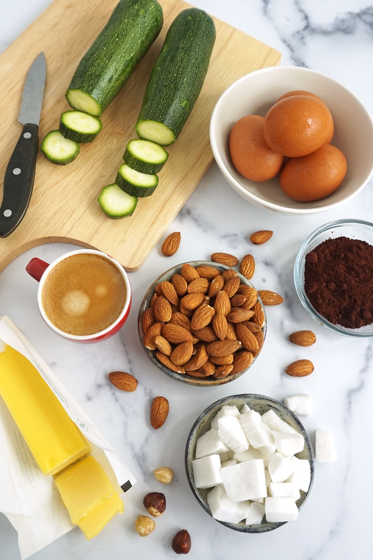 Ingredients on the counter: Zucchini, eggs, almonds, coconut, butter, dark chocolate and butter