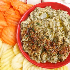 Baba Ghanoush in a bowl served with sliced carrots and radishes