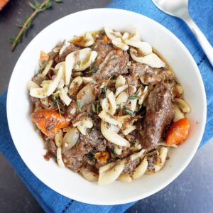 Bowl of beef stew with a spoon on the side