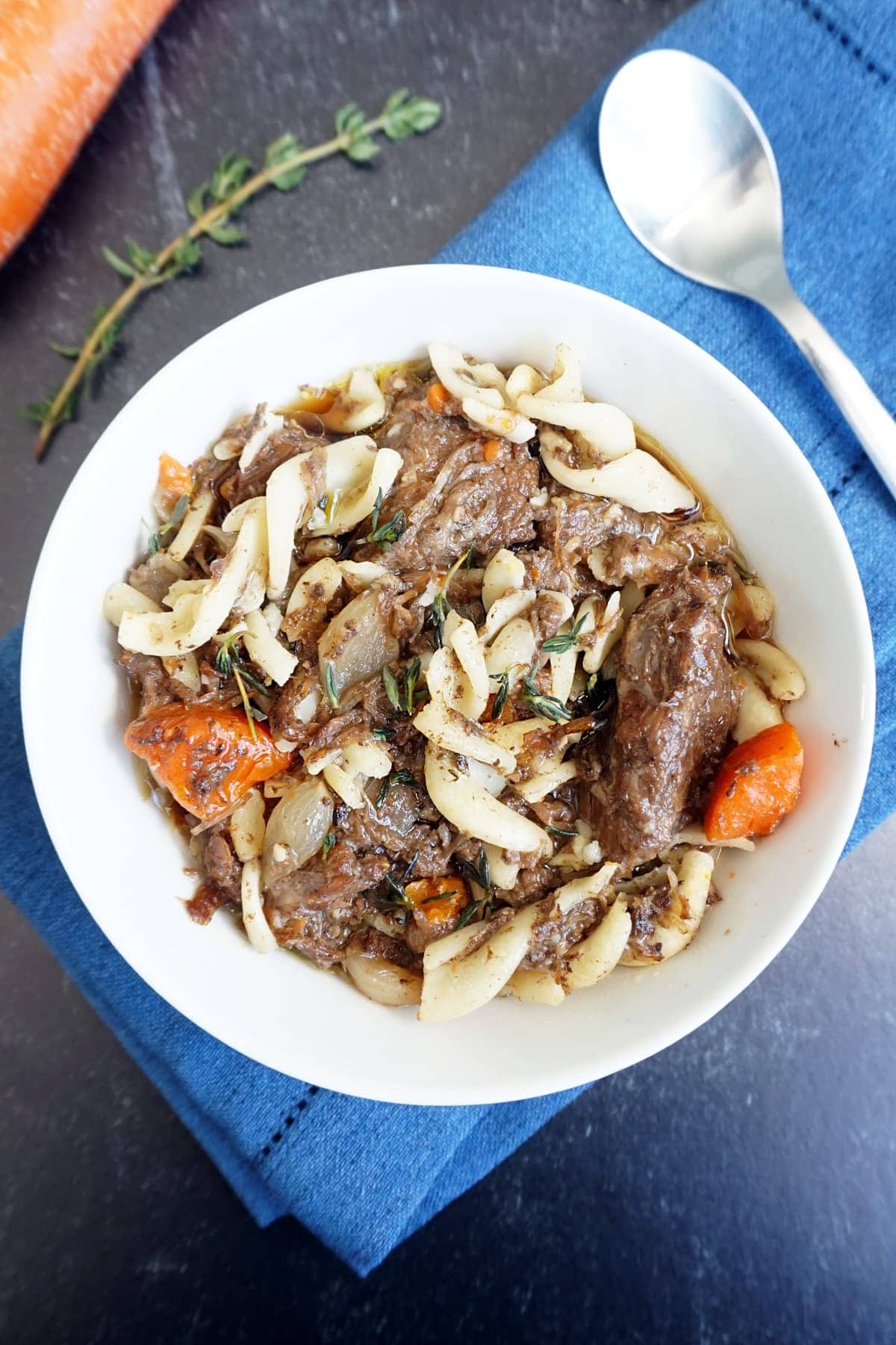 Bowl of beef stew with a spoon on the side