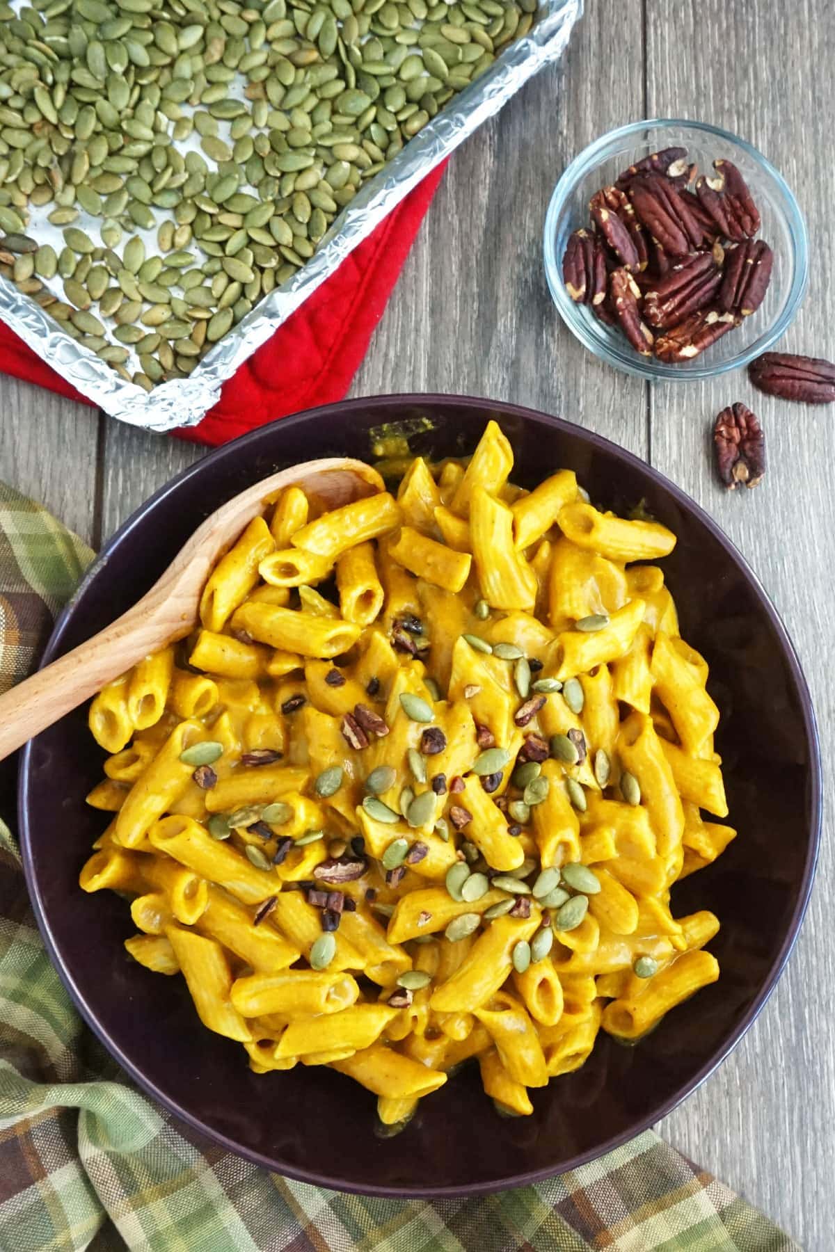 Serving dish of pasta with roasted pumpkin seeds in the background