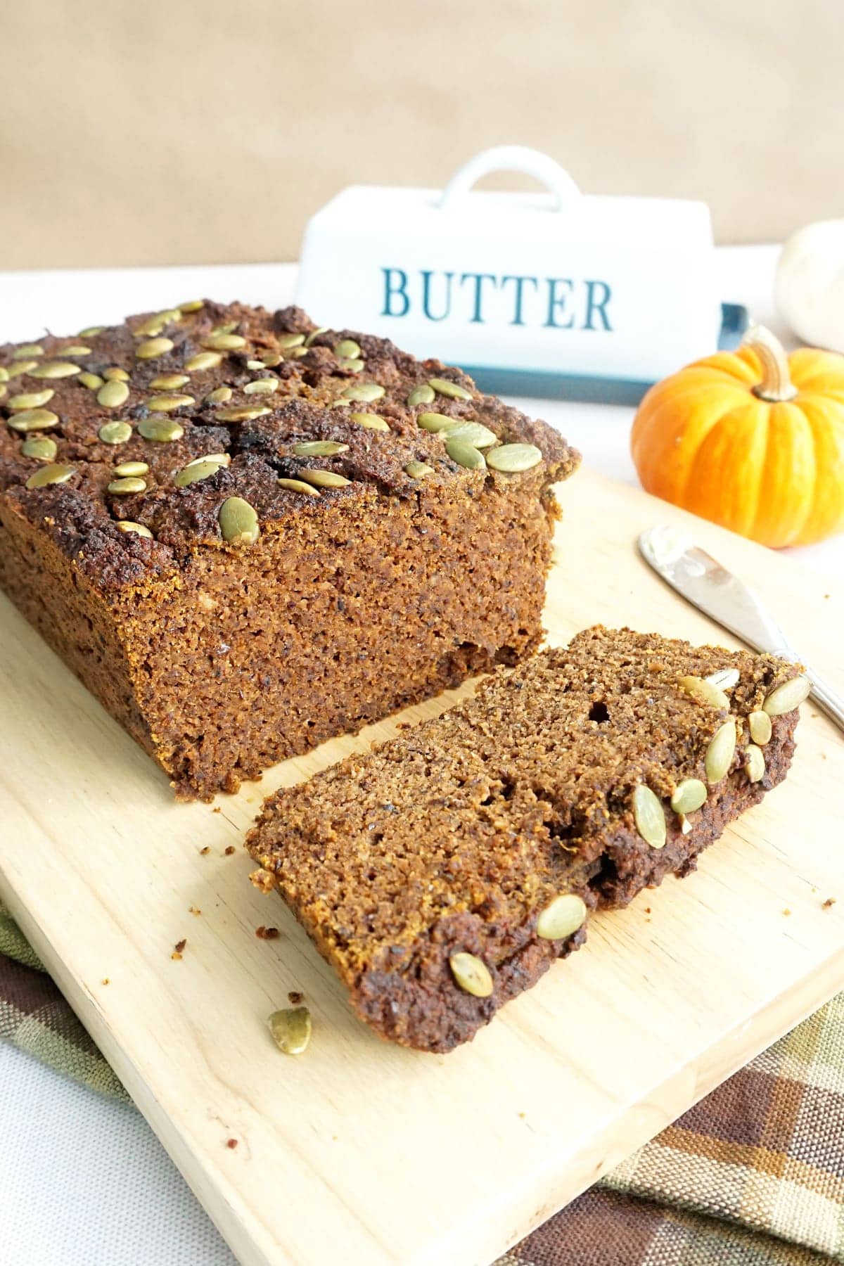 Slices of Hearty Keto Pumpkin Bread with Pecan & Flax next to the loaf