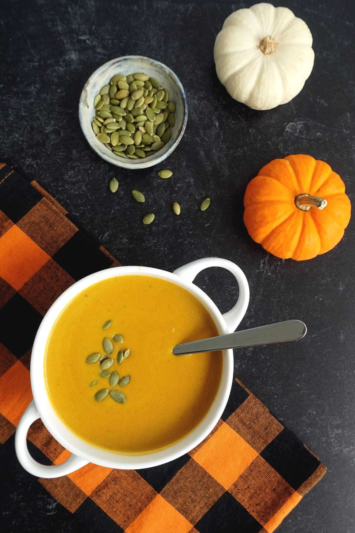 savory pumpkin soup with pumpkin seeds on the side