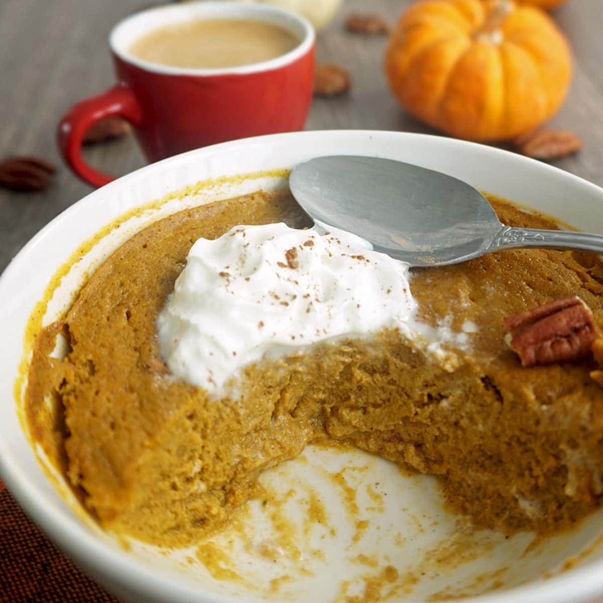 A bowl of half-eaten pumpkin pie with a mug of coffee on the side