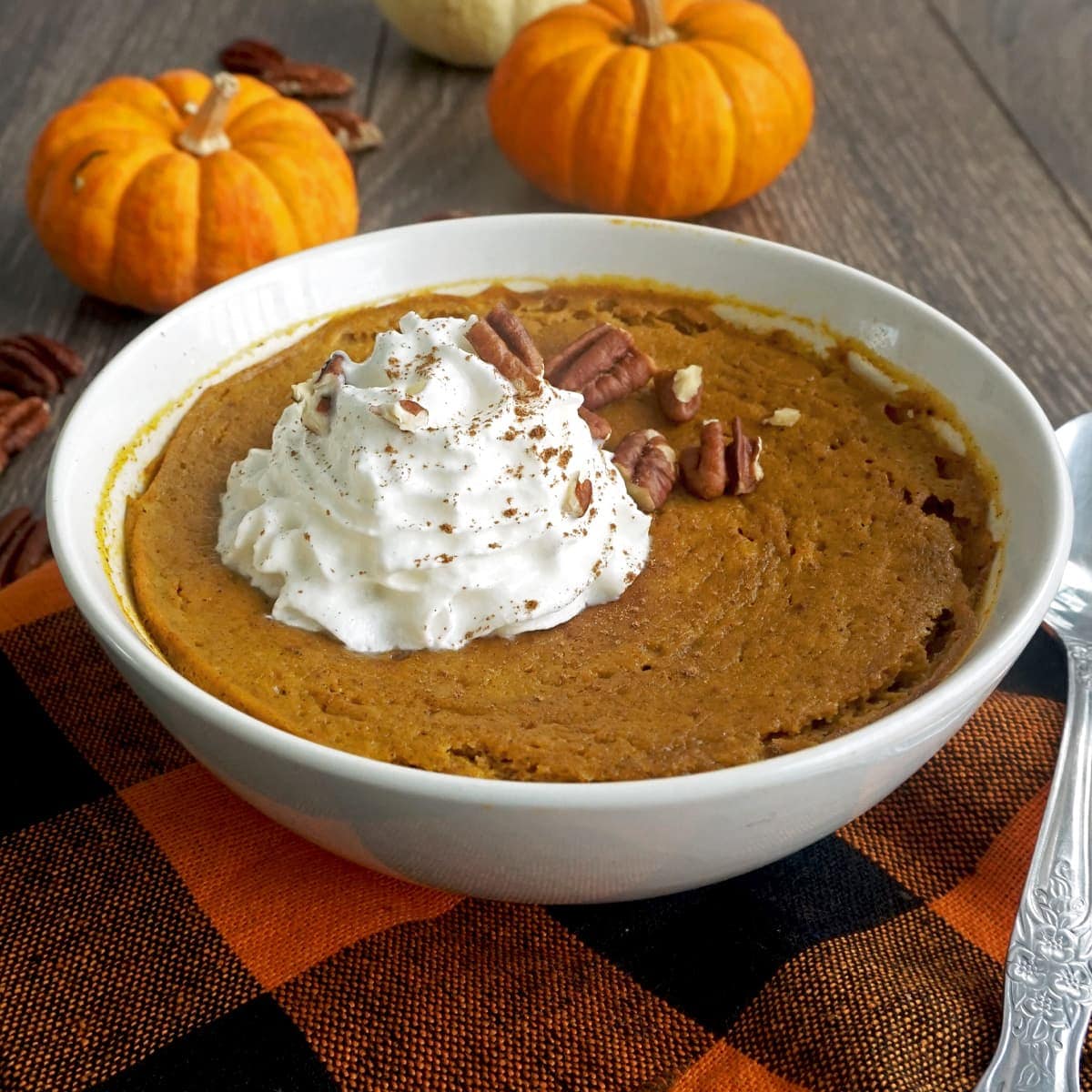 A bowl of pumpkin pie for breakfast with whipped cream and pecans on top