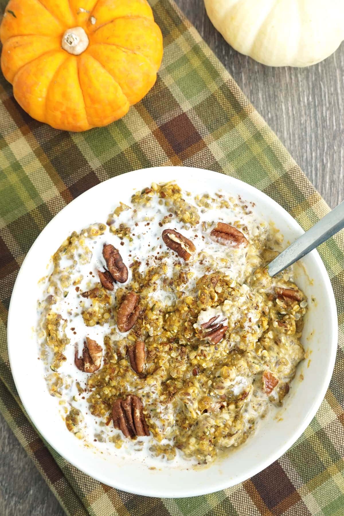 Bowl of keto low-carb pumpkin oatmeal with cream and pecans on top