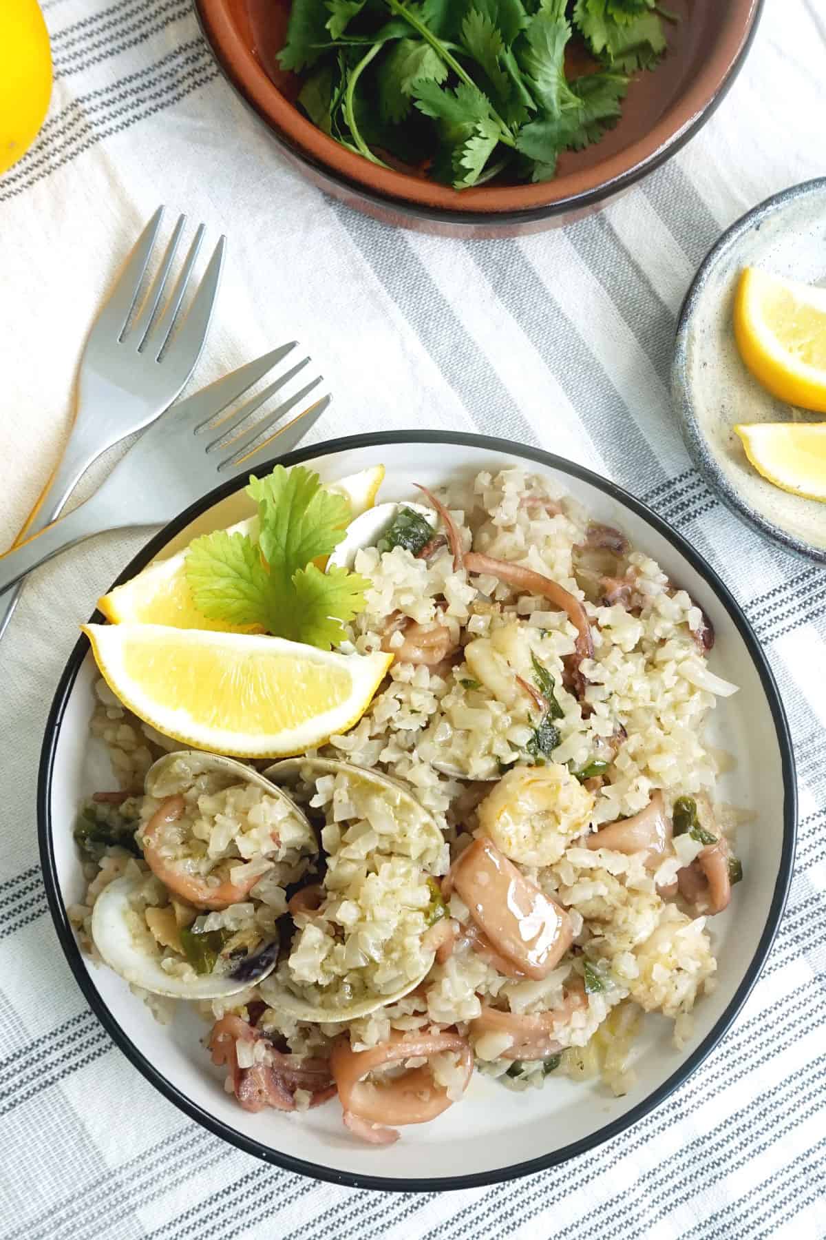 Bowl of seafood and rice with lemon on the side