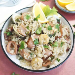 Bowl of seafood and rice with cilantro on top
