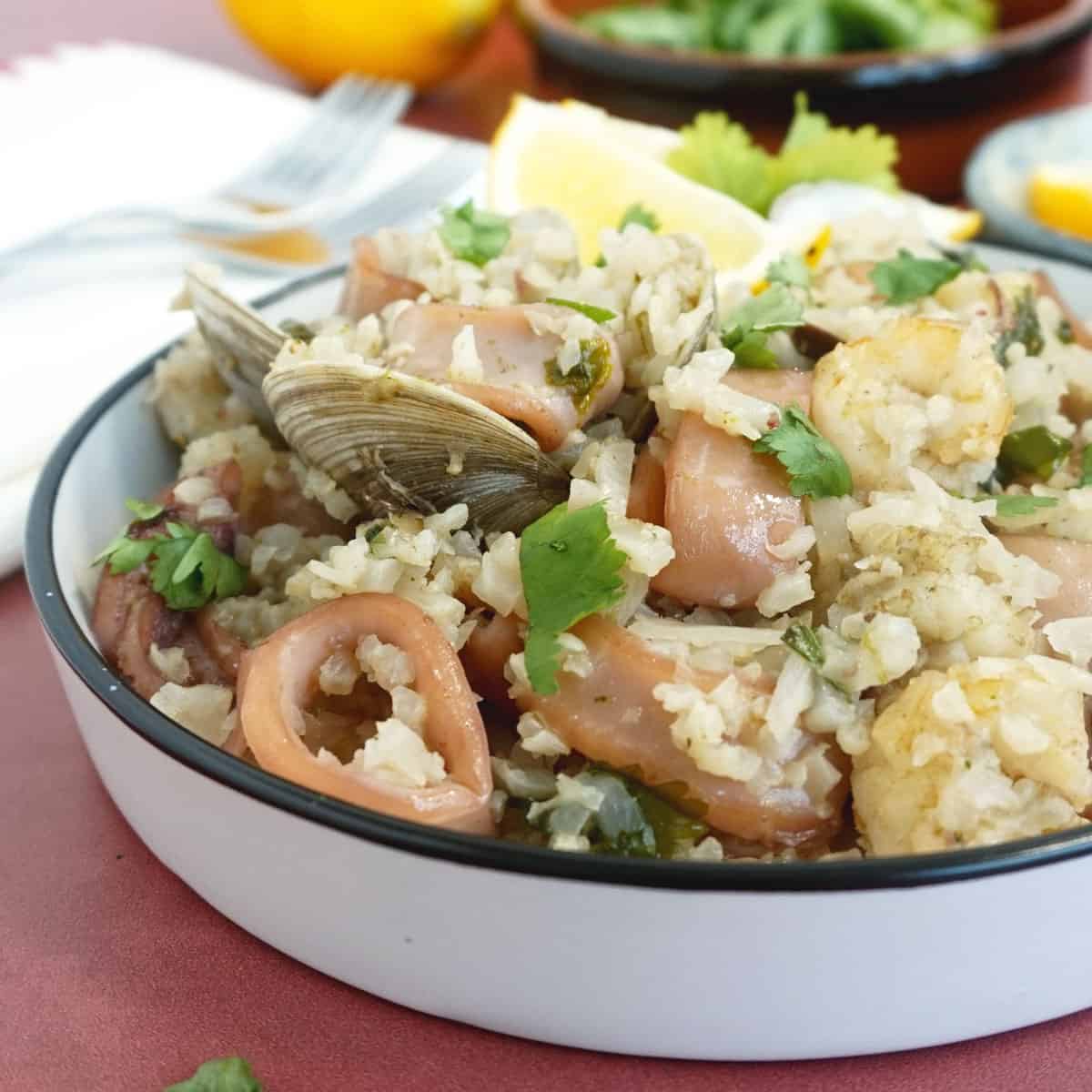 Bowl of seafood and rice with cilantro on top