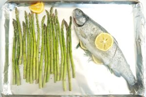 Sheet pan with raw fish and asparagus