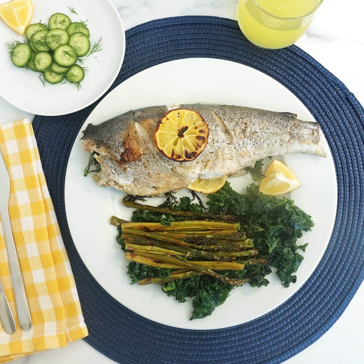 Plate of whole trout and kale and asparagus