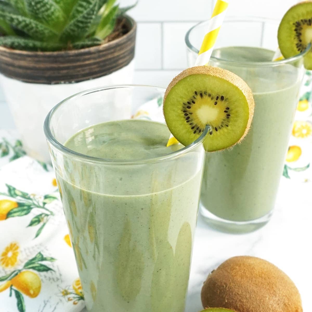Cup of Green Detox Smoothie with a kiwi and a yellow straw