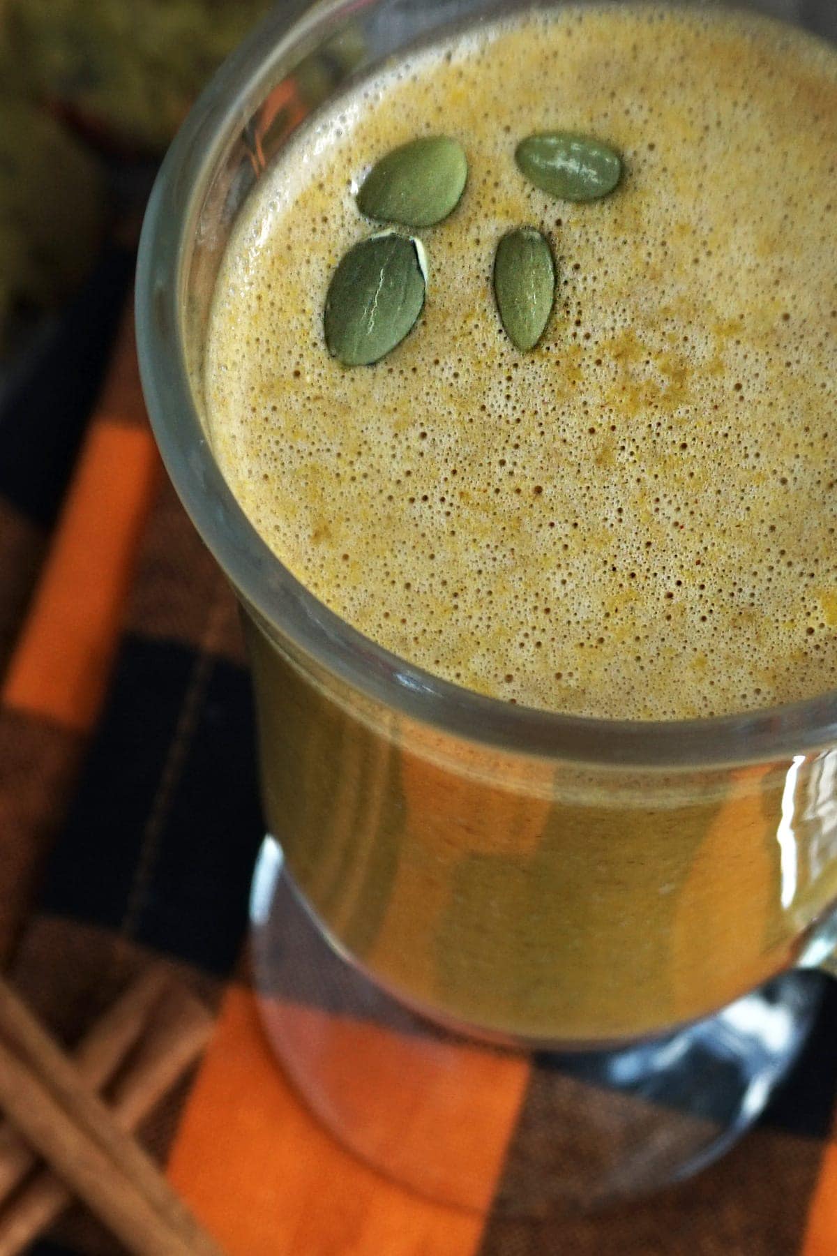 Cup of Low-Carb Pumpkin Spice Smoothie with pumpkin seeds on top